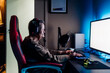 © Westend61 - Senior woman wearing headphones using computer while sitting at table