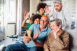 © Westend61 - Multiethnic family waving hands together while doing video call through smart phone at home