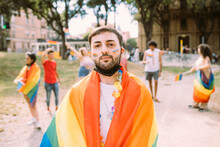 Young Man Wrapped In Rainbow Flag At Pride Event During COVID-19