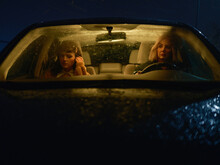 Two Women Sitting In A Car At Night