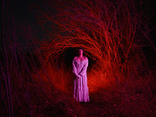 Ghostly Woman Stands At Night In The Woods.