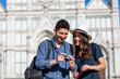 © Westend61 - Smiling tourists checking camera with Basilica Of Santa Croce in background at Florence, Italy