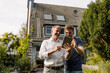 © Westend61 - Happy father and son using digital tablet while standing in backyard