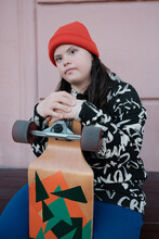 Pensive Young Woman With Skateboard