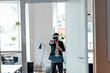 © Westend61 - Businessman with virtual reality headset stretching hand while standing in office