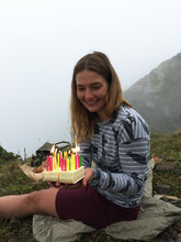 Smiling Woman With A Birthday Cake In The Mountains