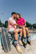 © Westend61 - Young couple sitting face to face at skateboard park on sunny day