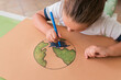 © Westend61 - Girl coloring Earth planet sketch at home
