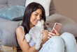 © boryanam - Beautiful  Smiling Woman Holding her Phone and Hugging with her Havanese Dog at Home