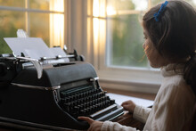 Child Sitting In Front Of Typewriter