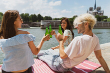 Man Smiling While Raising Toasts With Female Friends During Sunny Day