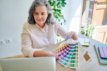 Female Design Professional Showing Color Swatch During Video Call Through Laptop