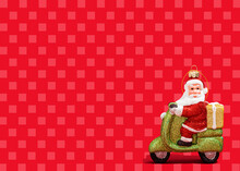 Christmas Ornament Of Santa Claus Riding Motor Scooter Against Vibrant Red Checked Background