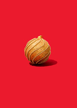 Studio Shot Of Single Gold-colored Christmas Ornament Lying Against Vibrant Red Background