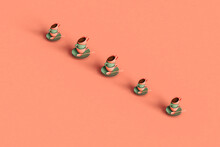 Three Dimensional Render Of Row Of Coffee Cups Stacked On Top Of Plates Flat Laid Against Pastel Pink Background