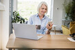 © Westend61 - Mature female professional using smart phone at desk in home office