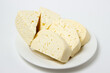 © Ruzanna - White cheese on a white background. Homemade white cheese on a plate. Traditional cuisine