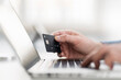 © Westend61 - Hand of businessman using laptop while holding credit card at workplace