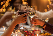 Holidays, Drinks And Celebration Concept - Close Up Of Hands Toasting Wine Glasses At Dinner Party On Christmas At Home