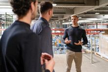 Young Male Professional Discussing With Colleagues At Factory