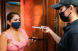 © Westend61 - Delivery woman scanning female customer's smart phone at doorway during pandemic
