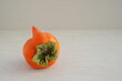 Strange forms of persimmon.  Ugly shape fruit in the gray background. Funny, unnormal fruit or food concept. Horizontal orientation.	