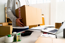 Businessman Carrying Cardboard Box At Desk