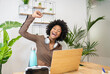 © Westend61 - Happy businesswoman raising hand while sitting with laptop at desk in office
