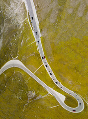 Wall Mural - Vertical panorama of a windy mountain road across the Alps, aeri