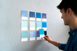 © Westend61 - Male entrepreneur selecting blue cards on wall