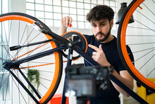 Male Vlogger Pointing At Bicycle Chain While Filming Tutorial At Home