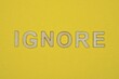 © butus - word ignore made from wooden letters lies on a yellow table