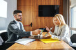 © Dusan Petkovic - Business people sitting in an office and having meetings. Man writing in a notebook while the woman is about to use a digital tablet. Cooperation, colleagues, teamwork, business talk