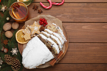 Wall Mural - Traditional Christmas Stollen with icing sugar on wooden table, flat lay. Space for text