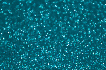 Glitter sparkling green texture. Beautiful Christmas and new year emerald bokeh blurred background