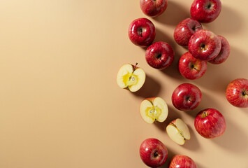 Wall Mural - A lot of apples placed on a beige background, cut in half or quarter.