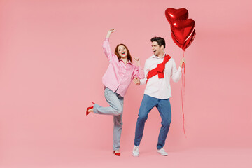 Wall Mural - Full size young couple two friend woman man in shirt hold bunch of red inflatable balloon dance isolated on plain pastel pink background studio portrait Valentine's Day birthday holiday party concept