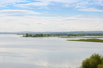 Wall Mural - Summer landscape with a view of a wide river and a settlement on the far bank