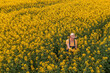 © Bits and Splits - Aerial view of female farmer with tablet computer in rapeseed field using innovative technology
