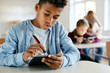 © Drazen - African American elementary student uses touchpad in classroom at school.