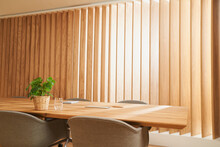 Conference table in front of wooden blinds at office