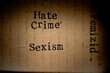 Gestempelter Text auf zerknittertem Pappkarton. Hate Crime, Femizid, Sexism.