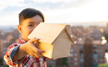 Boy Holding Wooden Architectural Model During Sunset