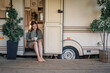 © Westend61 - Smiling young woman text messaging through smart phone while sitting at camper doorway