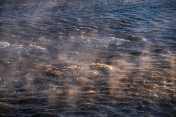 Wall Mural - River waves on a sunny, foggy winter morning