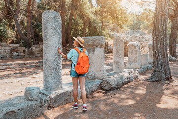 Wall Mural - Female traveler walks through the ancient ruins of the antic Greek city of Phaselis in Turkey. Historical sights and archeology