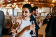 © Westend61 - Male and female friends drinking champagne and laughing at banquet