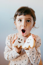 Cute Girl With Mouth Open Holding Ghost Cookies