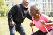 © Westend61 - Woman with resistance band exercising by man on sunny day