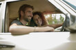 © Westend61 - Happy young couple in car traveling during road trip